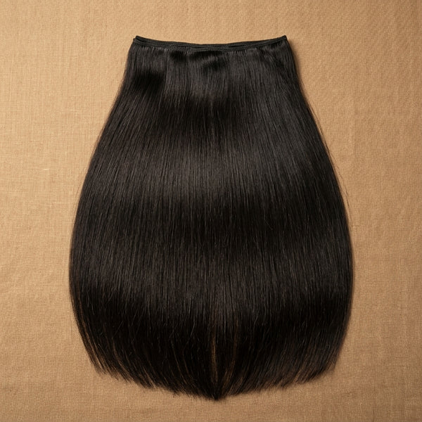 Adéorí Natural Straight virgin hair extension bundle flat lay on earthy surface