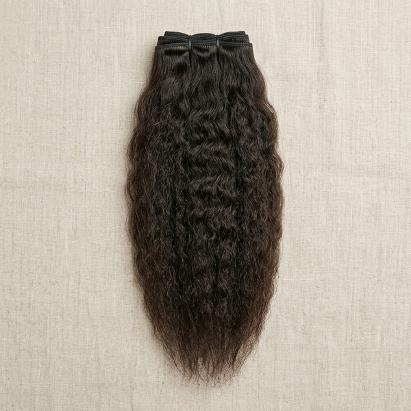 Adéorí Kinky Straight virgin hair extension bundle flat lay on earthy surface