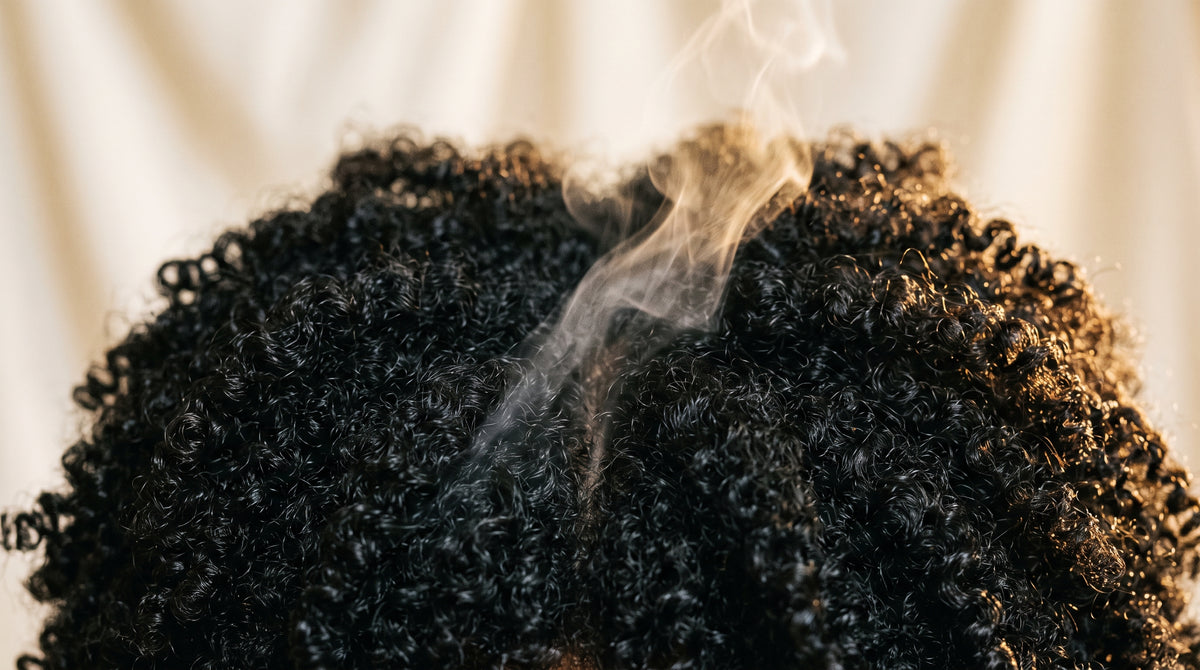 4C coily hair with a soft wisp of steam, evoking steam-set patterns