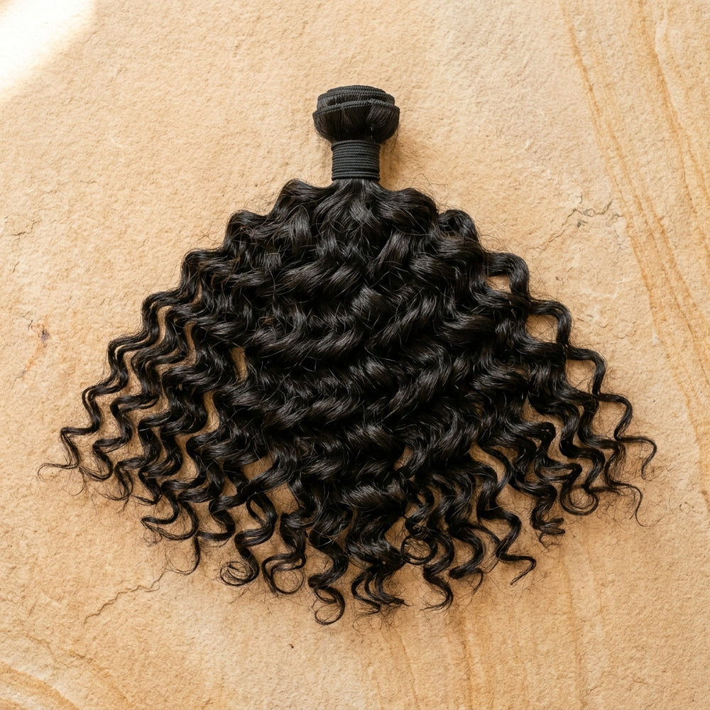 Adéorí Loose Curls virgin hair extension bundle flat lay on earthy surface