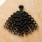 Adéorí Loose Curls virgin hair extension bundle flat lay on earthy surface